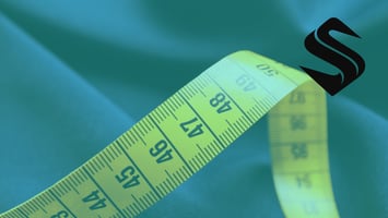 A dramatic close-up of a bright yellow measuring tape stretched diagonally across dark, tailored suiting fabric, representing precision and executive due diligence for Selkire's RevOps, HubSpot CRM, and marketing agency infrastructure audits