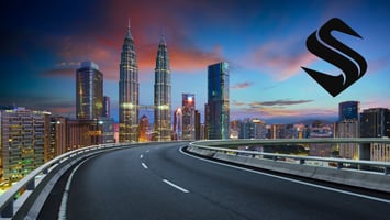 Elevated highway curving toward a lit city skyline at dusk, illustrating how SEO traffic must lead to a structured website built to convert visitors.