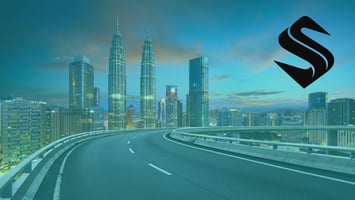 Elevated highway curving toward a lit city skyline at dusk, illustrating how SEO traffic must lead to a structured website built to convert visitors.